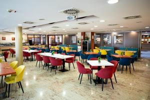 a restaurant with tables and colorful chairs at Airport Hotel Budapest in Vecsés