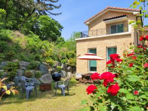 a house with a table and chairs and red flowers at 대전 SJ Haus in Daejeon