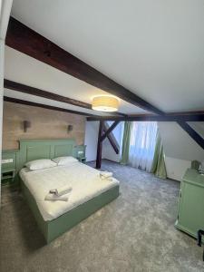 a bedroom with a large bed with two shoes on it at Pensiunea 7 Tei in Cisnădioara