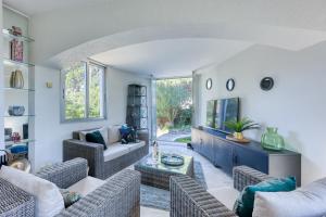 a living room with couches and a table at Maison Gecko - Proche de la plage in Cavalaire-sur-Mer