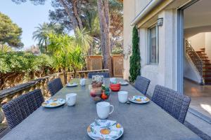 a table with plates of food on a patio at Maison Gecko - Proche de la plage in Cavalaire-sur-Mer