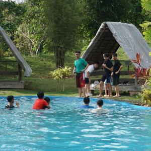 a group of children playing in a swimming pool at "D'BAMBOO KAMP" Desa Wisata Ekang in Lagoi