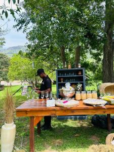 a man standing in front of a table with food at Lavender farm home in Port St. Johns