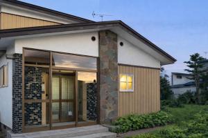 a house with a glass door and a window at 白樺 l リノベーション済 l 千歳空港まで30分 l 貸切の一軒家 l 8名様までOK in Yuni