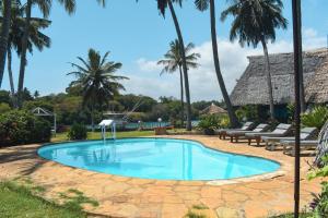 a swimming pool in a resort with palm trees at Horizon Bavaria Villa in Mtwapa