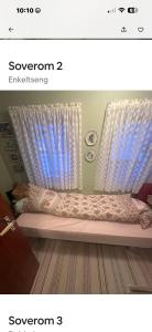 a bedroom with a bed with a curtain and a window at Helt hjem i lyngen in Lyngen