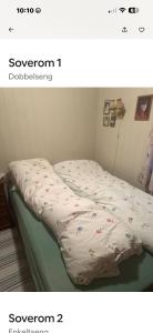 a bed with a comforter on top of it at Helt hjem i lyngen in Lyngen