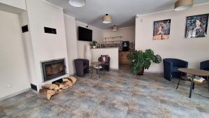 a living room with a fireplace and a table and chairs at Skalnica- apartamenty z widokiem na góry, przy szlakach in Karpacz