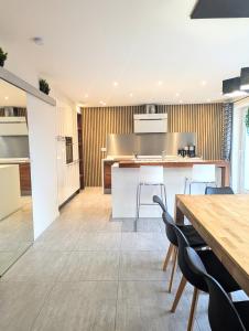 an open kitchen and dining room with wooden tables and chairs at La Chataigneraie in Châtenois