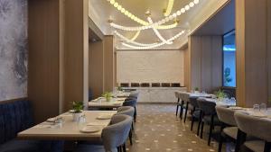 a dining room with tables and chairs and a chandelier at Dragonfly Hotel - The Art Hotel in Mumbai +105 photos