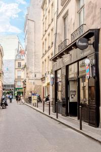 a street in a city with people sitting on the sidewalk at Studio Cosy - Le Marais centre in Paris +6 photos