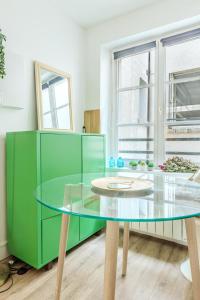 a glass table in a room with a green cabinet at Studio Cosy - Le Marais centre in Paris