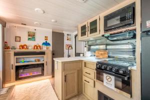 a kitchen with a stove and a microwave at Glamping Trailer Lanikai in Awaji