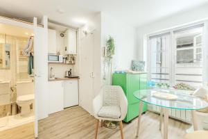 a kitchen and dining room with a glass table at Studio Cosy - Le Marais centre in Paris
