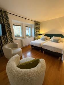 a hotel room with two beds and a chair at La Maison Dehlinger, chambres hôtelières et gîte in Gros-Réderching