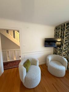 two chairs and a television in a living room at La Maison Dehlinger, chambres hôtelières et gîte in Gros-Réderching