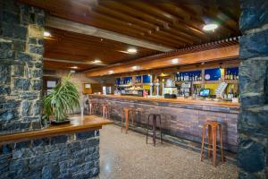 a bar with stools and a brick wall at Hostal Los Infantes in Olvega