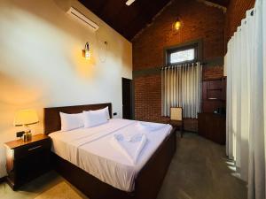 a bedroom with a large bed with a white blanket at Ranmin Lake Weerawila in Weerawila +84 photos