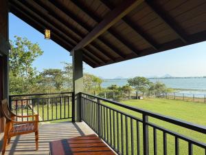 a porch with a chair and a view of the water at Ranmin Lake Weerawila in Weerawila