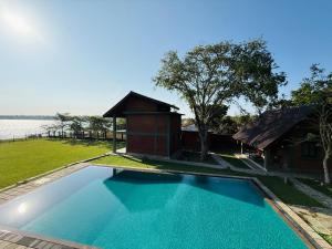 a swimming pool in front of a house with a building at Ranmin Lake Weerawila in Weerawila