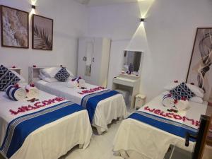 ein Hotelzimmer mit zwei Betten und einem Spiegel in der Unterkunft Ocean Sunset in Dhangethi + 40 Fotos