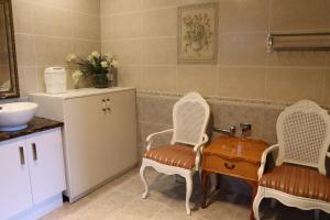 a bathroom with two chairs and a table and a sink at Midby's Elegant Guesthouse - 2 En-suite Rooms & 2 Rooms with Shared Bathroom in Perth +68 photos