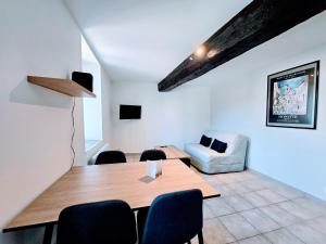 a dining room with a table and a couch at La Croix Duplex - Bail Partner in Chablis +5 photos