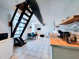a kitchen with a staircase and a living room at La Croix Duplex - Bail Partner in Chablis