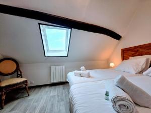 a bedroom with two beds and a window at La Croix Duplex - Bail Partner in Chablis