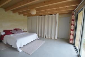 a bedroom with a white bed and a large window at Chambre d'hôtes La Folie in Vouhé