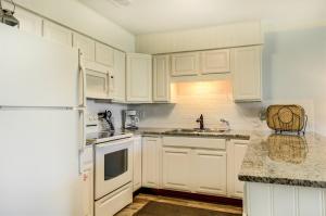 a kitchen with white cabinets and a white refrigerator at 10 A, One Bedroom Condo in Destin