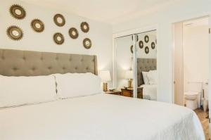 a bedroom with a white bed and mirrors on the wall at 10 A, One Bedroom Condo in Destin