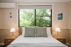 a bedroom with a bed and a large window at Ironbark Oasis - Serene Poolside Haven by Mudgee CBD in Mudgee +37 photos