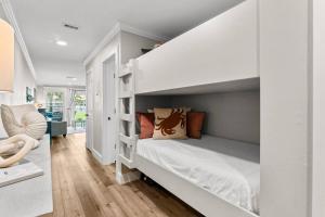 a bedroom with a white bunk bed with shelves at C' Salt 10B in Destin +22 photos