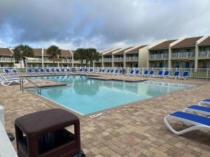 a large swimming pool with blue chairs and a grill at C' Salt 10B in Destin