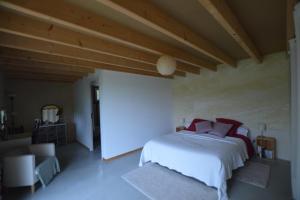 a bedroom with a large white bed with red pillows at Chambre d'hôtes La Folie in Vouhé