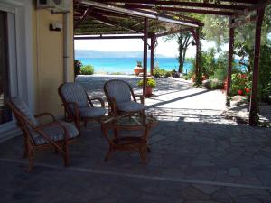 a patio with chairs and a table with a view of the ocean at Oasis apartment 1 in Alykí