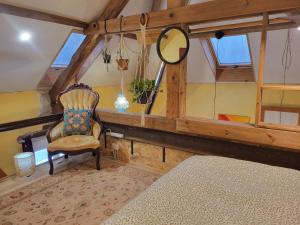 a room with a mirror and a chair in a room at Loft Apartment at Moulin SAGE in Treignac +16 photos