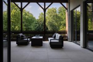 a screened porch with couches and a table at Park Lofts Groningen in Groningen