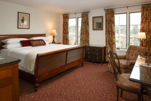 a bedroom with a bed and a chair and windows at Arizona Inn in Tucson +34 photos
