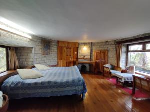 a bedroom with a bed and a fireplace at Khali Estate in Binsar