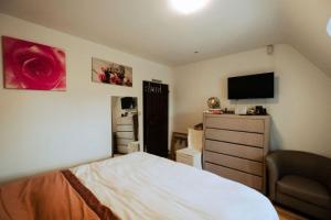 a bedroom with a bed and a dresser with a television at Rozerie BV in Waregem