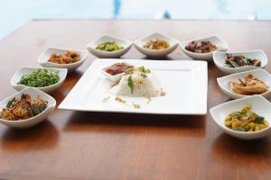 a plate of food on a table with bowls of food at Sandul Villa in Beruwala