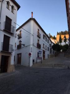 a white building with balconies on a street at Apartamento Cuesta San Judas in Antequera