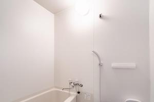 a white bathroom with a tub and a shower at ライズ201 in Kasugai
