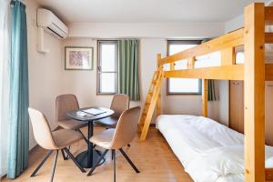 a bedroom with a bunk bed and a table and chairs at ライズ201 in Kasugai