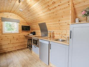 a kitchen in a log cabin with a sink at Oak View in Rhayader