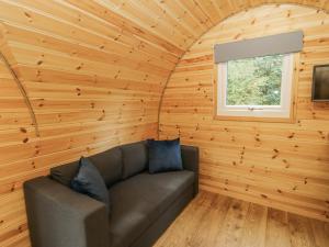 a living room with a couch in a wooden house at Oak View in Rhayader