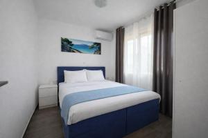 a bedroom with a blue bed and a window at Danai & Palm Stay Complex by Horizon Homes in Ofrínion +40 photos