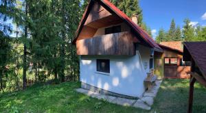 a small white building with a red roof at Bori Guest House in Miercurea-Ciuc